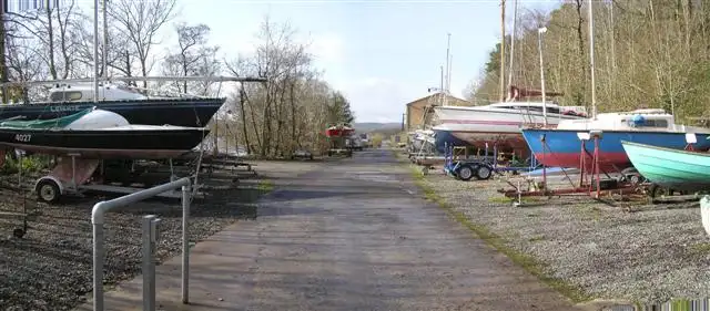 Segel- und Motorboote stehen auf Anhängern und Böcken entlang eines Weges im Gelände des Lough Erne Yacht Club in Killadeas.
