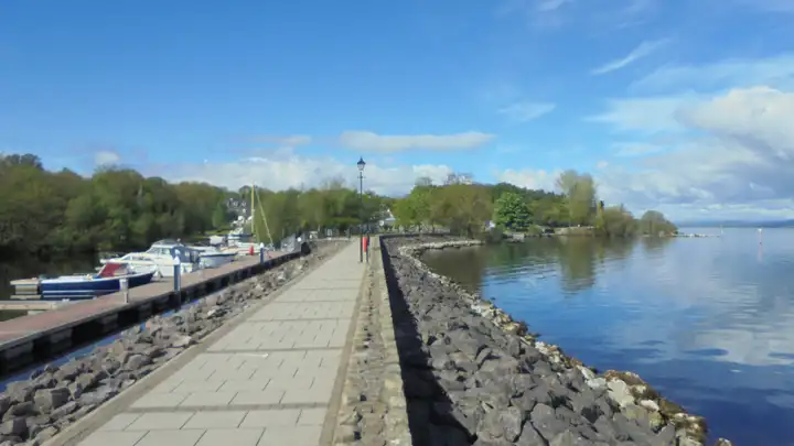 The paved breakwater at Garrykennedy, with motor cruisers at the floating jetties on one side and the open lake on the other.