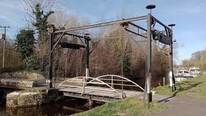 La structure en acier du pont levant vertical de Levitstown par une journée d’hiver ensoleillée, avec des bateaux amarrés le long de la berge.