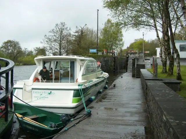 A hire cruiser waits at the wet stone quay at the foot of Battlebridge Lock, the entrance to the Lough Allen Canal.