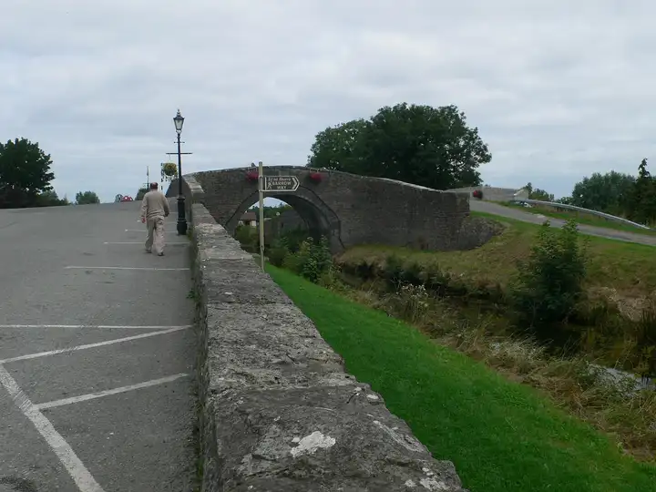 Le pont en pierre en dos d’âne de Binns Bridge à Robertstown, avec un panneau du Barrow Way, vu depuis le muret de la route du canal.