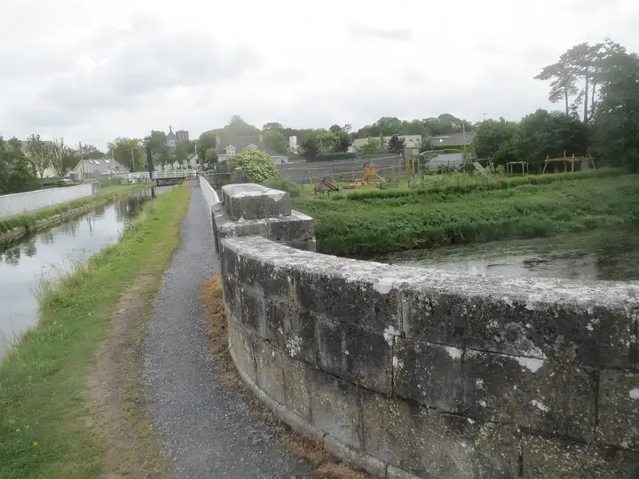 The stone parapet of the Monasterevin aqueduct, with the Barrow Line canal on the left, the River Barrow below on the right and the lifting bridge in the distance.