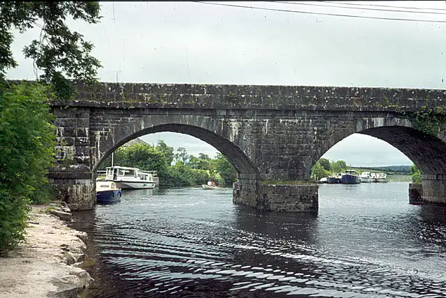 The arched stone bridge at Cootehall spans the River Boyle, with cruisers moored beyond its arches.