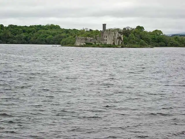 The ruined walls and tower of McDermott’s Castle on Castle Island, seen across the choppy grey water of Lough Key.