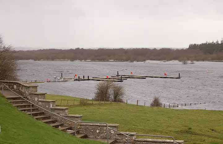 The floating jetty below Clonmacnoise seen from the stone steps of the site, with the Shannon in winter flood over the fields.