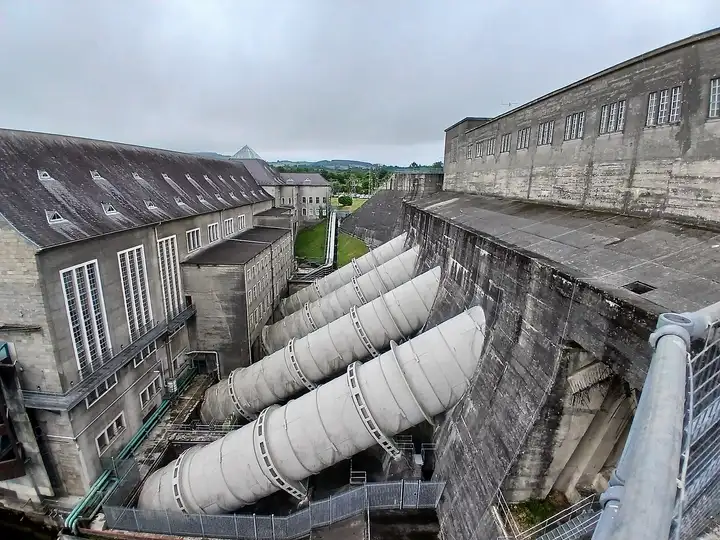 D’énormes conduites forcées descendent du mur de prise d’eau en béton vers le bâtiment principal de la centrale d’Ardnacrusha.