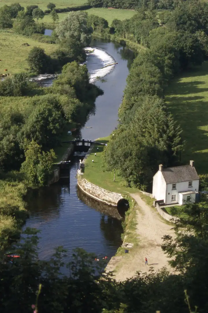 Looking down from the hillside onto Clashganny Lock, the lock house and the curving weir on the River Barrow.