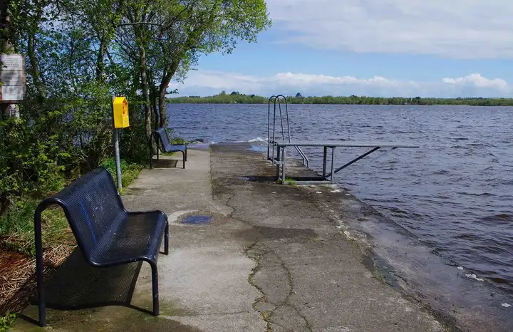 The old stone quay at Youghal with benches, a swimming ladder and a diving board above the choppy lake.