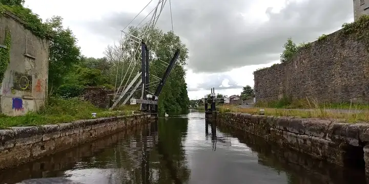 Blick flussaufwärts durch die Kammer der Schleuse von Bagenalstown, links die Klappbrücke, rechts alte Mühlenmauern.