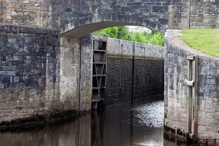 The stone chamber and steel gates of Ballyconnell Lock (Lock 2), seen through the arch of the bridge that spans the end of the lock.